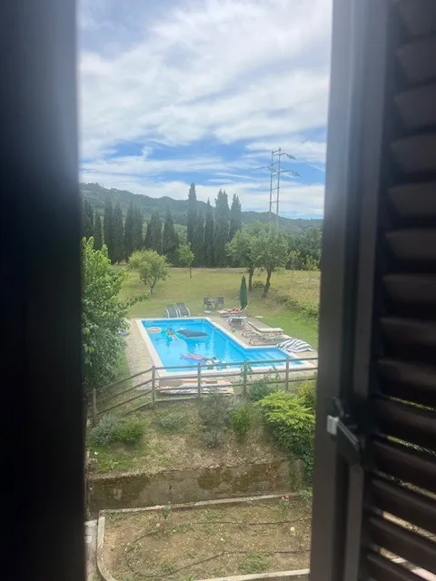 Uitzicht vanuit raam over zwembad en heuvels